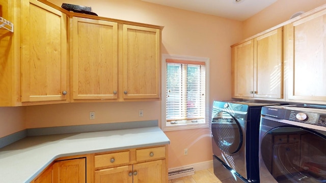 laundry room with washer and dryer, light tile patterned flooring, and cabinets