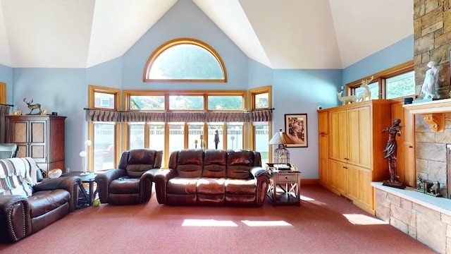 living room with a wealth of natural light, a fireplace, carpet floors, and high vaulted ceiling