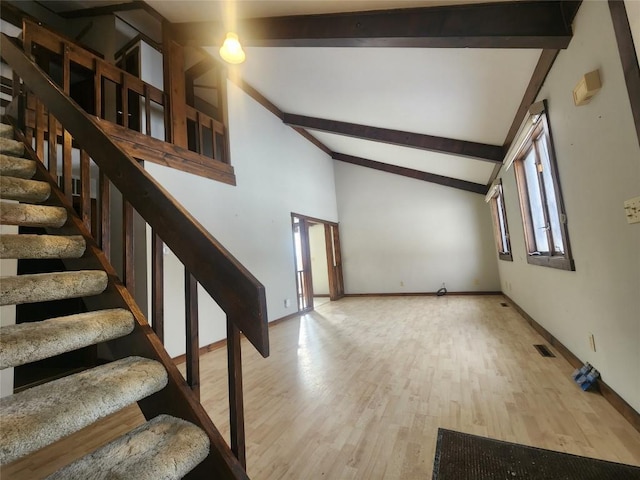 stairway with high vaulted ceiling, wood-type flooring, and beamed ceiling