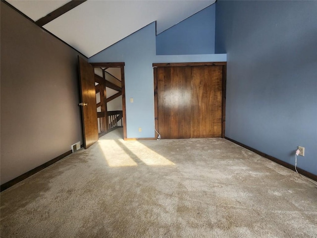 empty room featuring light colored carpet and vaulted ceiling