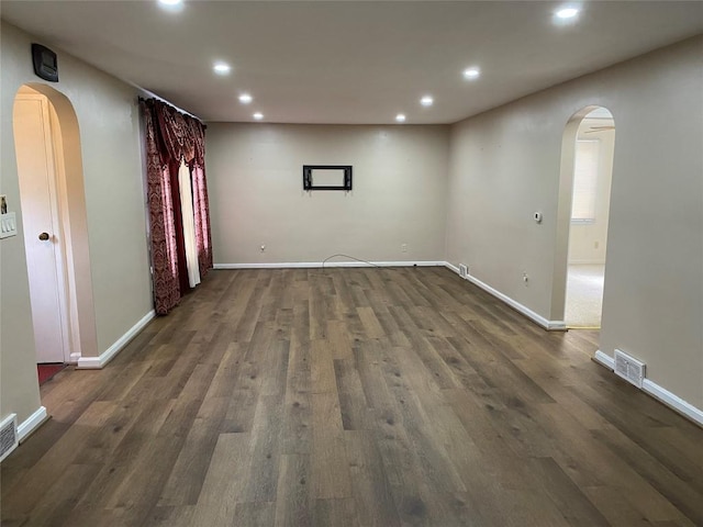 interior space featuring arched walkways, recessed lighting, and dark wood finished floors