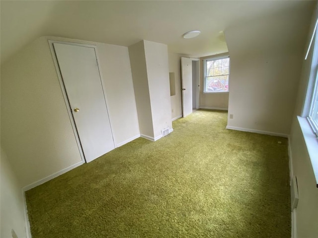 unfurnished bedroom featuring baseboards, vaulted ceiling, and carpet