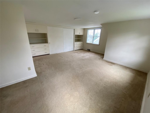 unfurnished bedroom with baseboards, a closet, and light carpet