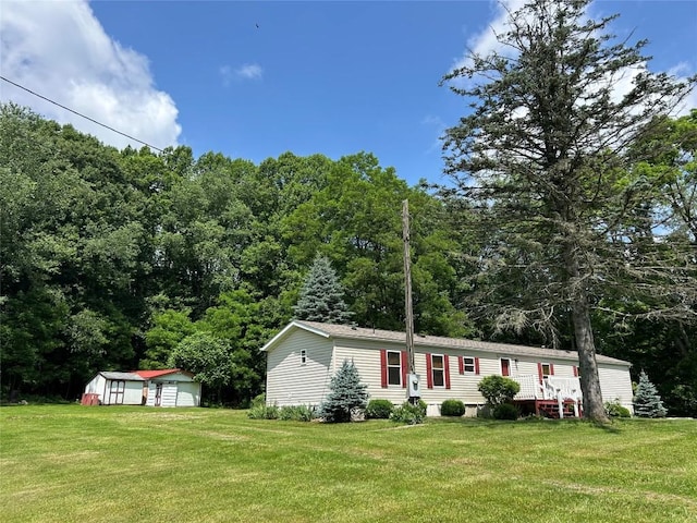 263 W Jamestown Rd, Jamestown, PA 16134 - manufactured / mobile home featuring a shed, a detached garage, a front lawn, and a view of trees