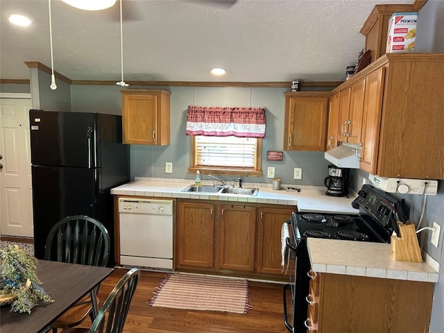 263 W Jamestown Rd, Jamestown, PA 16134 - kitchen featuring black appliances, under cabinet range hood, dark wood finished floors, brown cabinetry, and crown molding