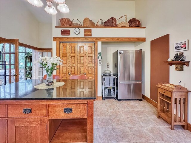 8350 Carbury Rd, Edinboro, PA 16412 - kitchen with freestanding refrigerator, a towering ceiling, baseboards, and brown cabinetry