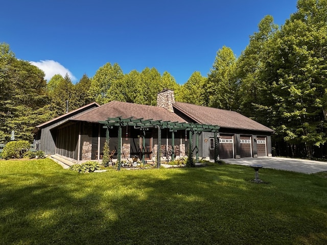 8350 Carbury Rd, Edinboro, PA 16412 - rear view of house featuring a garage, a chimney, a lawn, driveway, and stone siding