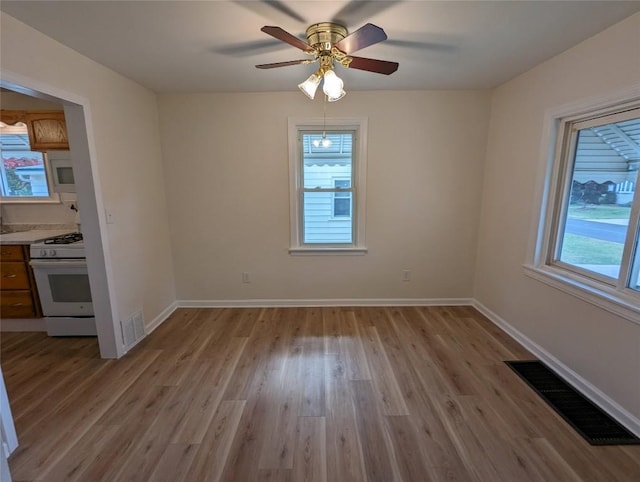 unfurnished dining area featuring light hardwood / wood-style floors and ceiling fan