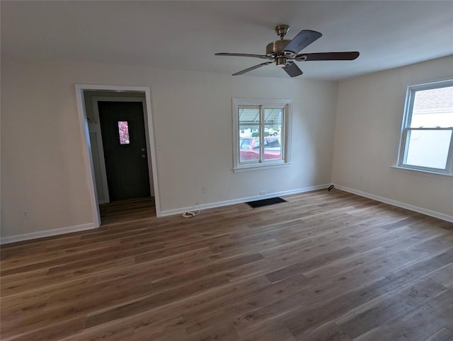 empty room with dark wood-type flooring and ceiling fan