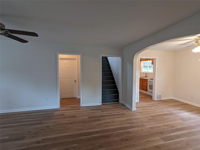 spare room with sink, ceiling fan, and light wood-type flooring