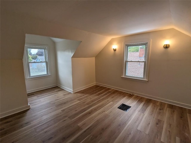 bonus room featuring lofted ceiling, plenty of natural light, and hardwood / wood-style floors