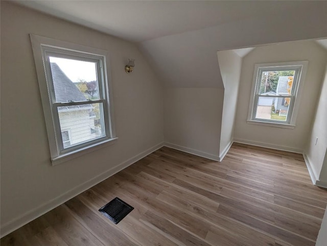 bonus room featuring lofted ceiling and light hardwood / wood-style floors