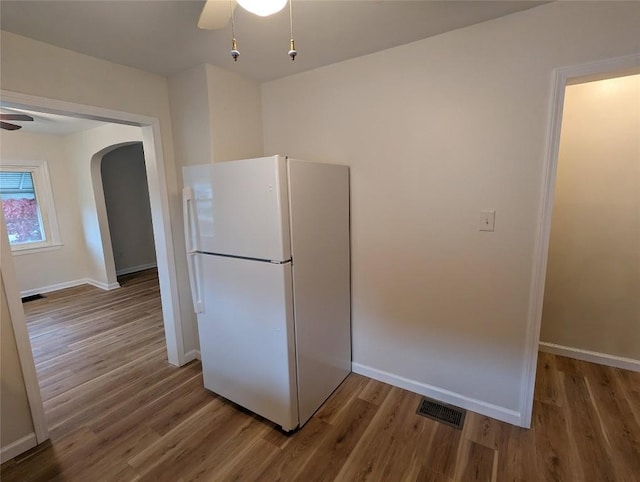 kitchen featuring hardwood / wood-style floors, ceiling fan, and white fridge