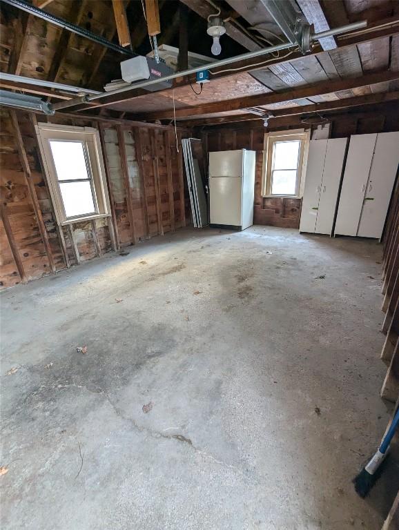 garage with white refrigerator and a garage door opener