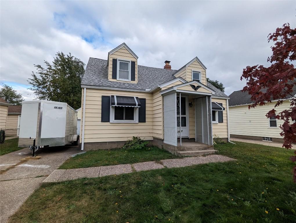 cape cod house featuring a front yard