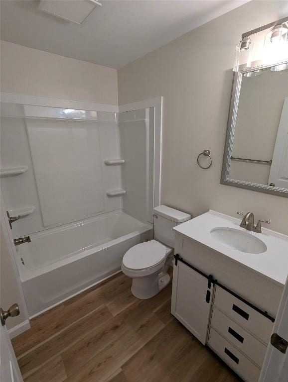 full bathroom featuring wood-type flooring, tub / shower combination, vanity, and toilet