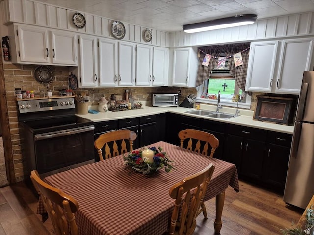 26418 State Highway 18, Albion, PA 16401 - kitchen with stainless steel appliances, white cabinets, dark cabinetry, and light wood-style flooring