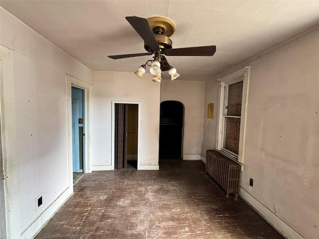 1029 E 25th St, Erie, PA 16503 - unfurnished living room with radiator, tile patterned floors, ceiling fan, and arched walkways
