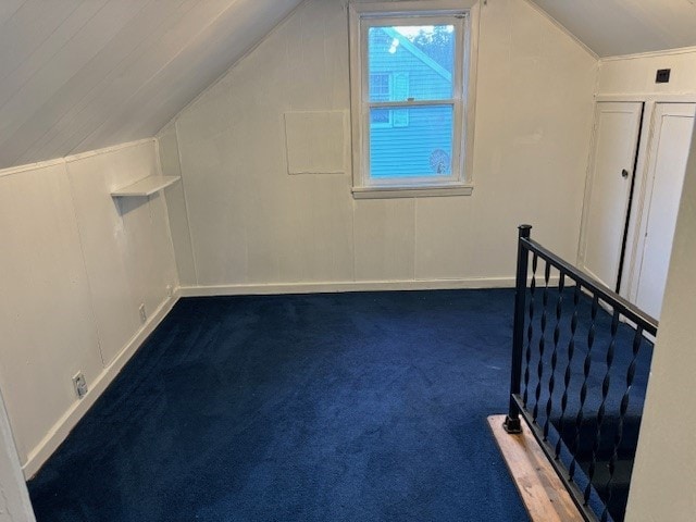 bonus room with dark carpet and lofted ceiling