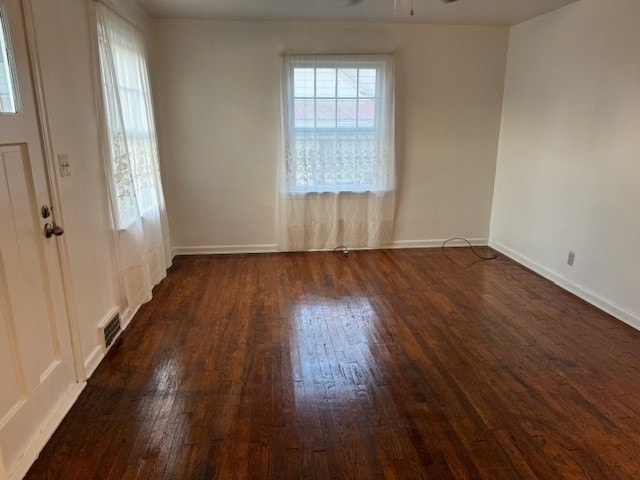 spare room featuring ceiling fan, dark hardwood / wood-style flooring, and a wealth of natural light