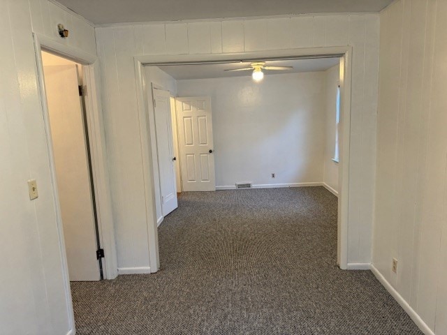 hall featuring dark colored carpet