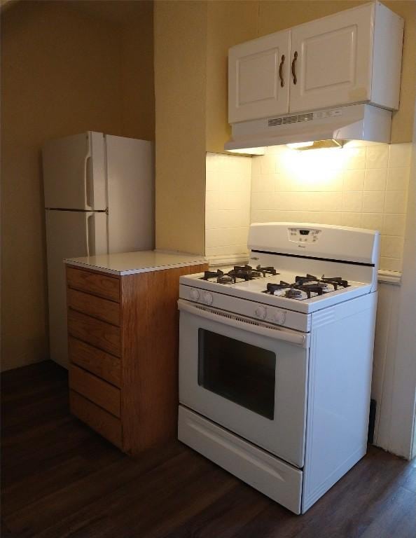 kitchen with white cabinets, dark hardwood / wood-style flooring, and white appliances