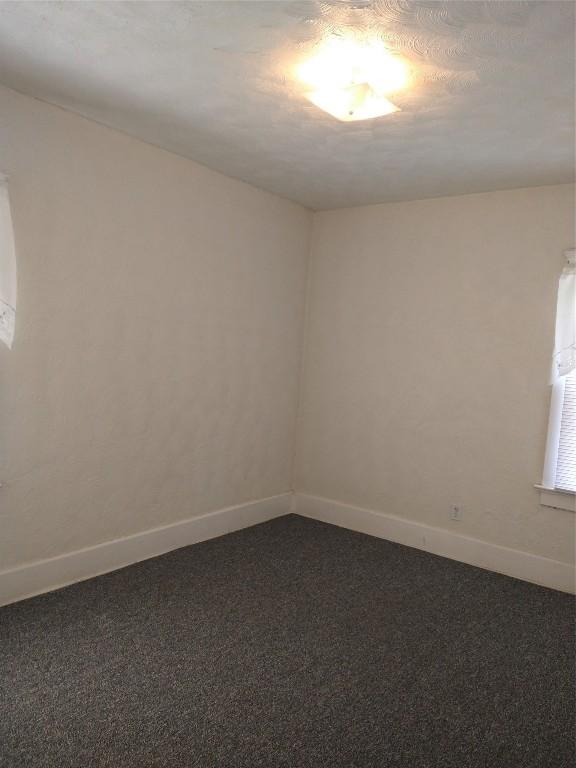 carpeted spare room with a textured ceiling