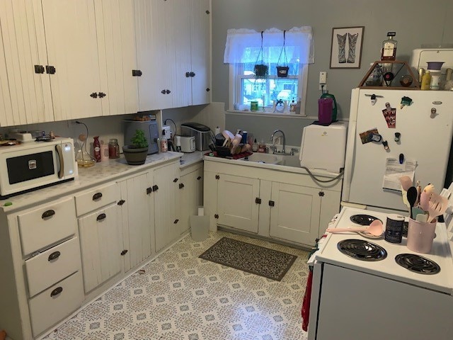 kitchen featuring sink, white cabinets, and white appliances