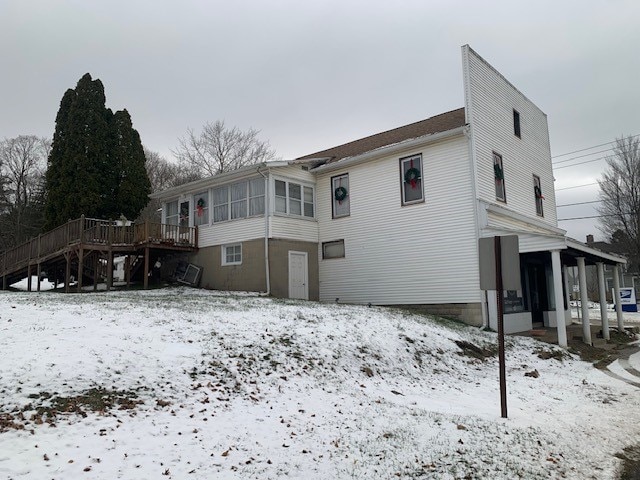 snow covered property with a wooden deck