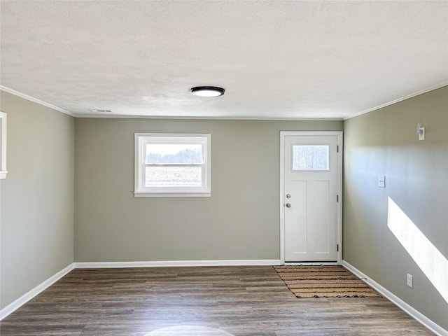 entrance foyer with crown molding, visible vents, a textured ceiling, wood finished floors, and baseboards