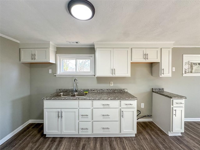 kitchen with white cabinets, dark wood finished floors, dark stone counters, and a sink