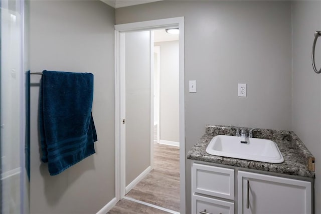 bathroom with baseboards, wood finished floors, and vanity