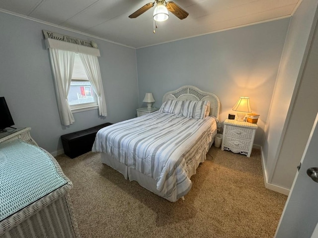 carpeted bedroom with ceiling fan and ornamental molding