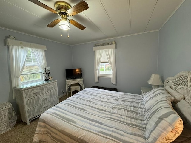 carpeted bedroom with multiple windows, ceiling fan, and ornamental molding