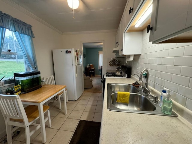 kitchen featuring sink, white cabinets, white appliances, light tile patterned floors, and ornamental molding