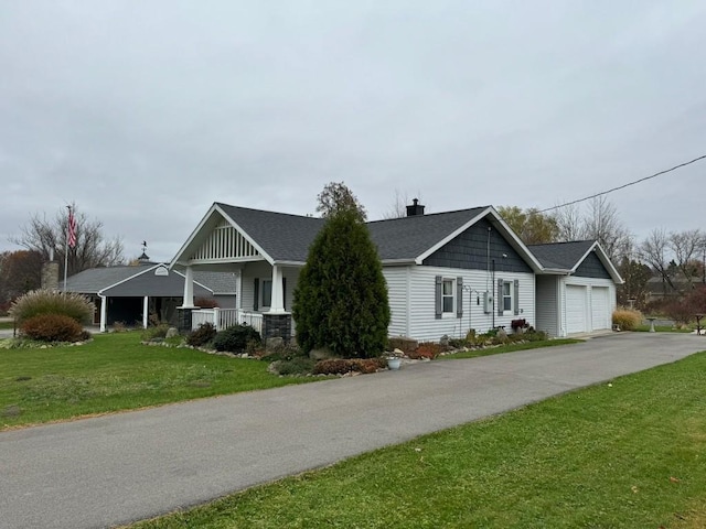 view of front of property with a porch, a garage, and a front lawn