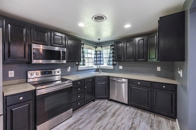 10220 Barton Rd, Waterford, PA 16441 - kitchen featuring appliances with stainless steel finishes, light countertops, light wood finished floors, recessed lighting, and dark cabinets