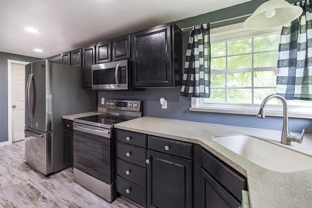 10220 Barton Rd, Waterford, PA 16441 - kitchen featuring stainless steel appliances, light countertops, light wood-style floors, dark cabinets, and recessed lighting