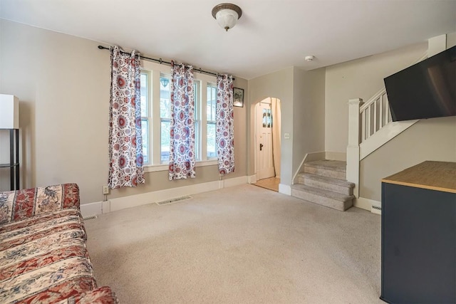 1047 Napier Ave, Erie, PA 16511 - unfurnished living room with carpet floors, arched walkways, stairs, and baseboards