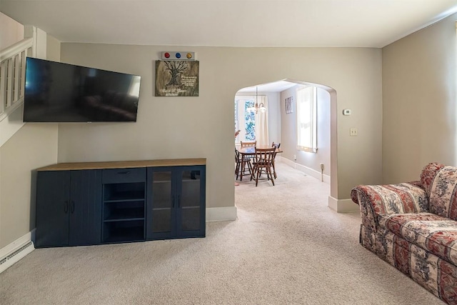 1047 Napier Ave, Erie, PA 16511 - living room with arched walkways, light colored carpet, a baseboard radiator, and baseboards