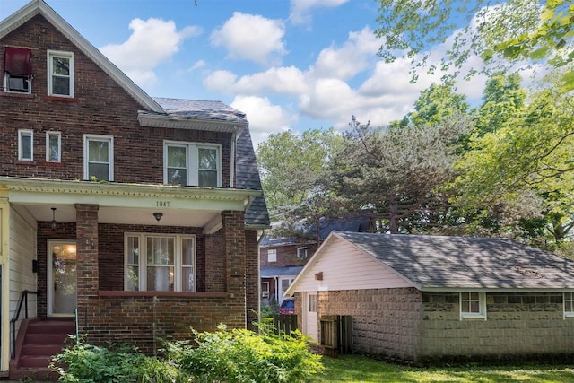 1047 Napier Ave, Erie, PA 16511 - view of side of property featuring brick siding, a porch, and roof with shingles