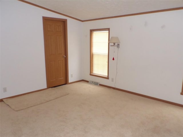 carpeted spare room featuring crown molding and lofted ceiling