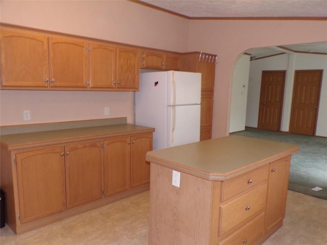 kitchen featuring a center island, white fridge, and light carpet