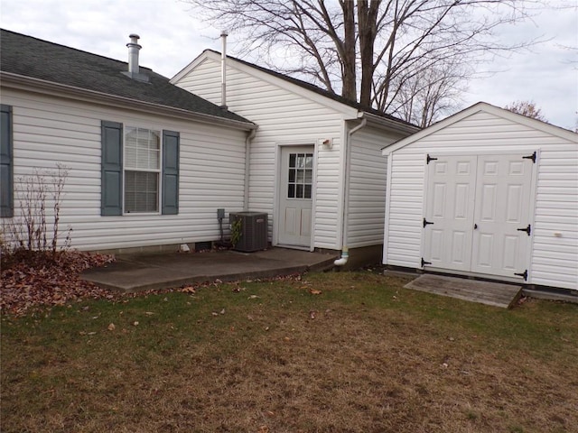 back of house with central air condition unit, a patio area, and a lawn