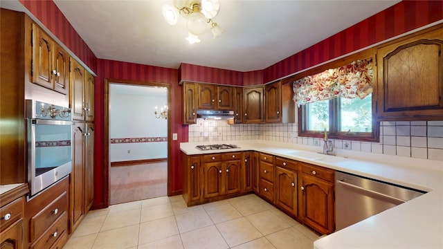 8410 Windsor Beach Ct, Erie, PA 16511 - kitchen featuring a chandelier, appliances with stainless steel finishes, under cabinet range hood, and light countertops