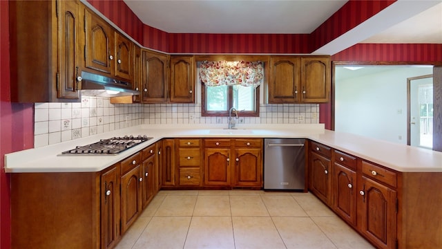 8410 Windsor Beach Ct, Erie, PA 16511 - kitchen with appliances with stainless steel finishes, under cabinet range hood, a peninsula, light countertops, and decorative backsplash