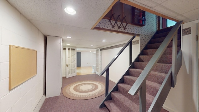 8410 Windsor Beach Ct, Erie, PA 16511 - stairway featuring concrete block wall, recessed lighting, a paneled ceiling, and carpet floors