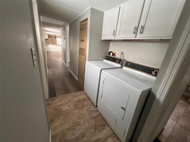 clothes washing area featuring washing machine and dryer and cabinet space