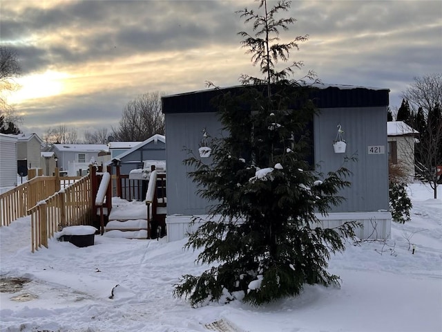 view of snowy exterior featuring a residential view and a deck