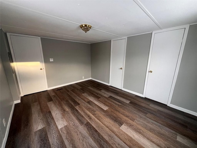 unfurnished bedroom featuring baseboards and dark wood finished floors